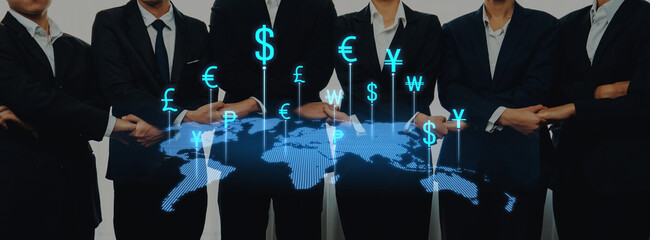 A group of business professionals in suits stands together, posing confidently with a digital world map and various global currency symbols depicting international finance and trade. Trope