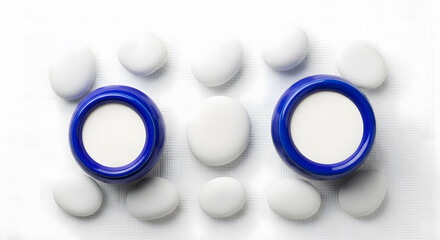 Two blue circular objects and smooth white stones arranged symme