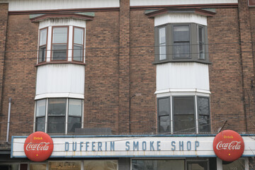 Naklejka premium a historic/old signage from a long-closed smoke shop (Dufferin Smoke Shop) with vintage Coca-Cola button signs, Dundas St W Toronto