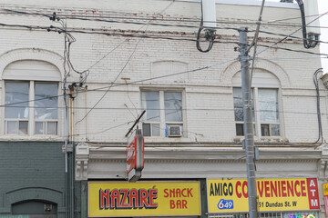 Naklejka premium exterior building facade and signs of Nazaré Snack Bar and Amigo Vape & Convenience at 1151 Dundas St W, Toronto