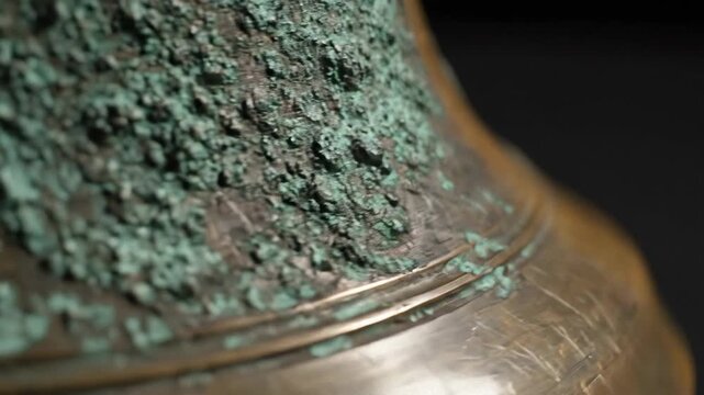 Close Up of Aged Bronze Bell Surface with Green Patina and Scratches Isolated on Dark Background