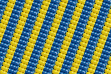 Obraz premium Yellow and blue pills on blue surface. Top flat view