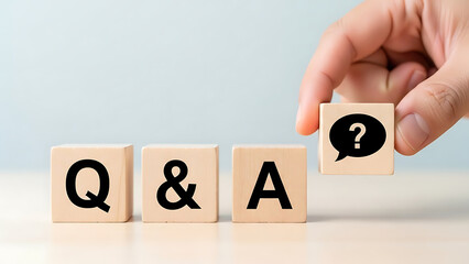 Hand puts wooden cube with speech bubble question mark icon to complete the Q&A text