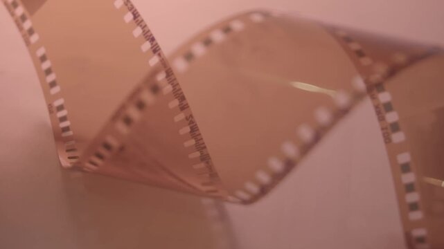 35mm negative photographic film in rotation .Slightly rolled film strip Analog film strips. Analog photography.Nostalgic memory Close-up. 