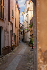 Obraz premium Albenga, Liguria, Italy - August 19, 2025 Medieval houses in Albenga, characterized by narrow alleys called carrugi, and arches, support bridges between the houses in the historic center, in the