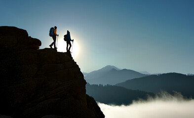 Hikers Reaching Mountain Summit Above the Clouds at Sunrise