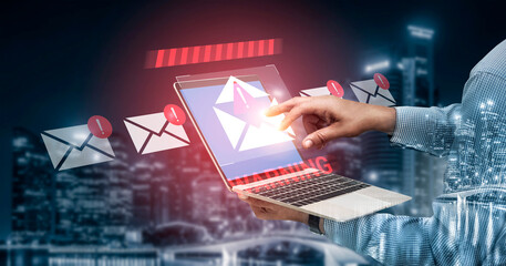 A modern businessman interacts with a laptop displaying email notifications against a vibrant urban backdrop, showcasing technology and connectivity in today digital world. Gantry