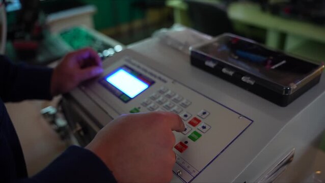 a worker enters parameters while operating a machine