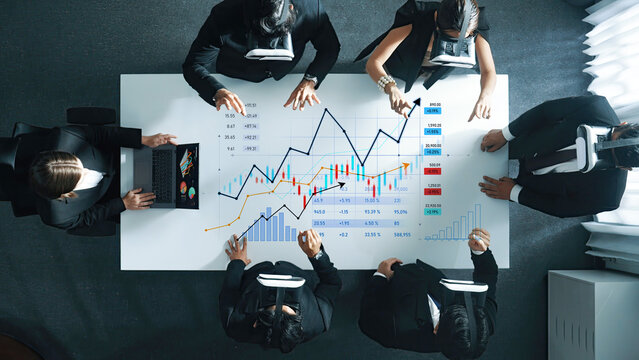 Dynamic group of diverse business professionals immersed in data analysis using virtual reality headsets in a modern office, showcasing a collaborative approach to strategic planning. Scalp - Powered by Adobe
