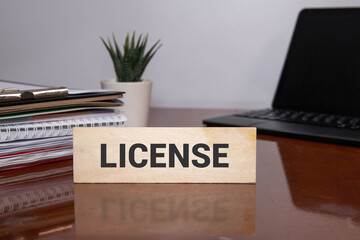 Business person presses his finger on the wooden cubes with the word licensing.