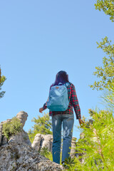 A woman tourist with a backpack on her back walks through the ancient city of Selga, admiring the wonderful nature and wonderful rocks. Turkey, Antalya