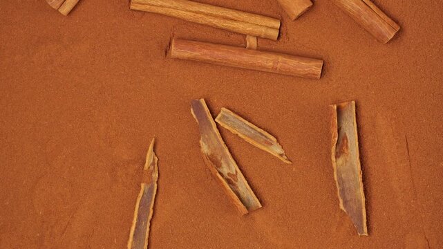 Aromatic cinnamon sticks lying on cinnamon powder