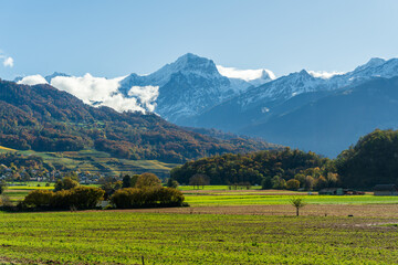 Obraz premium St-Triphon outskirts autumn fields and snowy mountains in Rhone Valley. Saint-Triphon, Canton of Vaud, Switzerland.