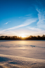 Der zugefrorene Maschsee in Hannover bei Sonnenuntergang mit der Abendsonne im Winter mit Schnee und Eis 