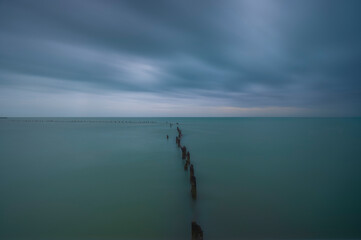 Long exposure storm clouds passing over wood pilings in Key West Florida 