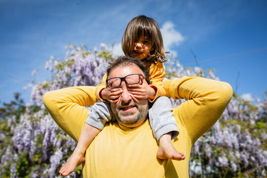 smiling father and daughter in yellow clothes playing together