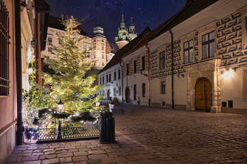 Nocne zdjęcie Krakowa ukazujące oświetlone zabytki, brukowane ulice i klimatyczną atmosferę miasta. © BMC