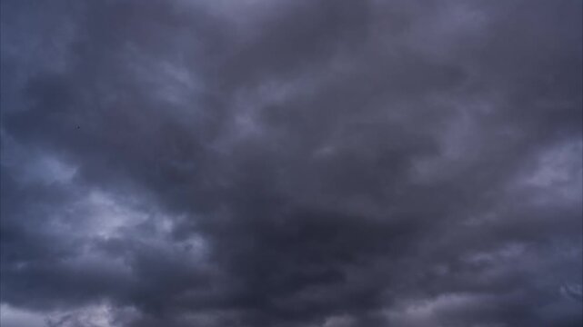 Time lapse of moving clouds across a dramatic sky, showing natural motion, changing light and atmospheric weather conditions.