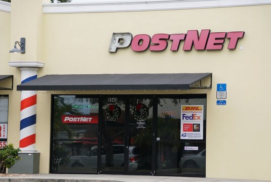 Sarasota, Florida, U.S.A - Jan 4, 2026 - The storefront of a PostNet shipping center authorized to handle DHL, FedEx, UPS, and USPS mail services