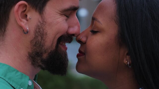 Young interracial couple sharing a tender kiss in an urban setting, embracing love and celebrating diversity with genuine affection and deep emotional connection