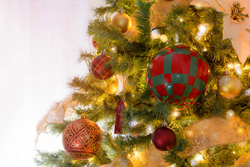 Close up of an Christmas tree decorated with colourful baubles and fairy lights in a living room. Selective focus and copy space.