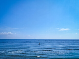 Naklejka premium Tranquil morning atmosphere at a tropical shore featuring gentle ocean ripples and a serene horizon. This high-quality travel photography captures the authentic and quiet side of East Bali's coastline