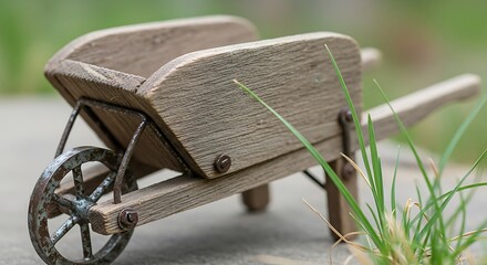 Miniature wooden wheelbarrow conveying rustic charm with grass accents