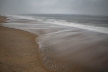 Minimalist seascape with soft ocean waves on empty beach, calm and peaceful background