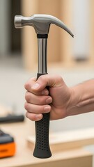 A person holding a hammer in their hand in a workshop