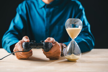 Gamer with joystick controller plays video game, hourglass shows sand time for gaming console concept, demonstrating player focus on limited play hour