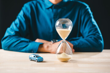 Person evaluates car finance, hourglass shows time running out, emphasizing need for smart money saving and careful buying to manage loan cost insurance and future depreciation