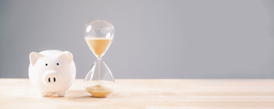 Piggy bank and hourglass symbolize saving money over time, important financial planning concept showing diligent management of funds for future growth, retirement, business investment