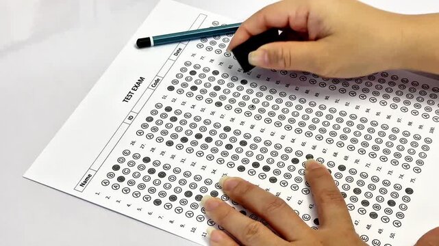 Education concept, close up of hand writing on test paper. University admission or final exam assessment concept.