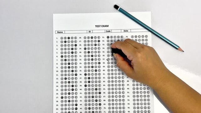 Education concept, close up of hand writing on test paper. University admission or final exam assessment concept.