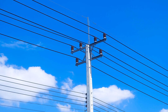 high voltage power lines against blue sky