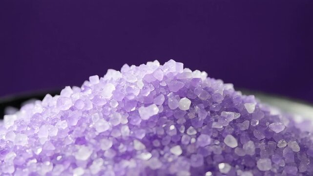 Pile of coarse purple sea salt in macro style featuring deep violet and lavender colors used for aromatherapy wellness treatments and relaxing spa body care procedures
