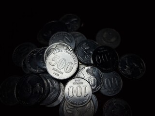 Stack of metallic coins under dramatic light.