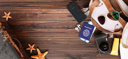 Flat lay travel accessories and passport on wooden background for summer vacation concept