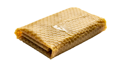 A folded sheet of yellow honeycomb wax, showcasing its intricate hexagonal pattern. The wax appears soft and pliable, suggesting its use in crafting. transparent background