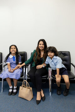 Happy mum waiting with kids in doctor's waiting room