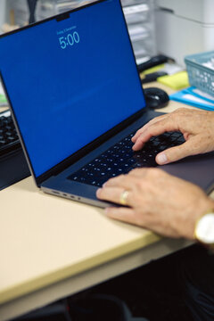 Close-up view of hands actively typing on a laptop keyboard