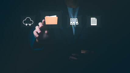 Businessman touching folder icon with cloud storage and document symbols, Concept of digital data management, cloud computing technology, online archiving, and paperless office systems.