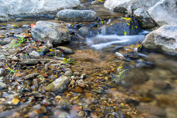 closeup waterfall stream and rocks stones on nature clear motion flow water in autumn natural forest garden or jungle at Phalad Waterfall in Lan sang national park for foot massage or summer landscape