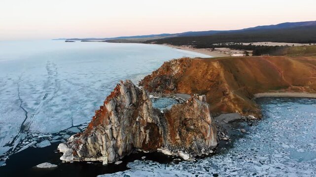 Aerial view of Cape Burkhan on Olkhon Island. Lake Baikal in the spring at sunset. The period of melting ice on the lake, the ice drift.