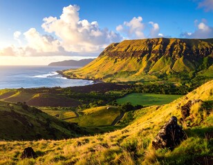 A vibrant coastal landscape features lush green hills, a rugged mountain range, and a sparkling ocean under a cloudy sky