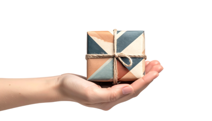 A hand holding a small gift box wrapped in colorful geometric pattern paper. Secured with a natural hemp rope bow, giving a rustic and artisanal look.