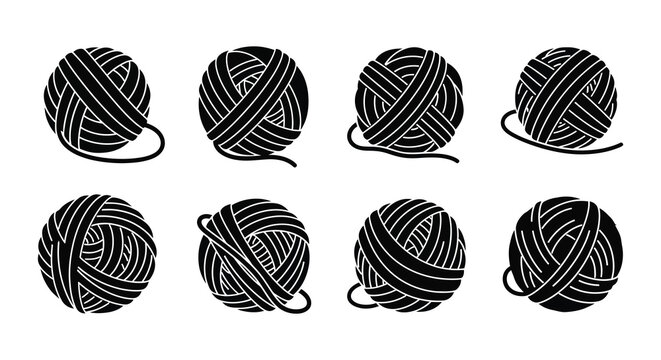A collection of black and white yarn balls some with loose ends arranged neatly