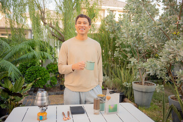 Asian man happily drip coffee beans in him home garden.