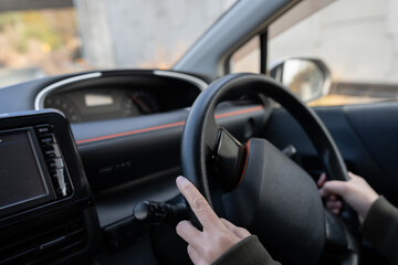 Naklejka premium 自動車のハンドルを持つ人の手元 