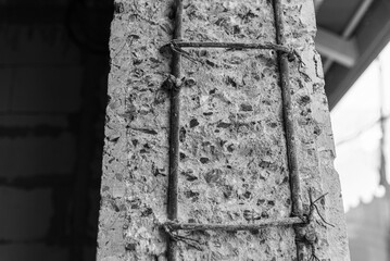  Close up of a reinforced concrete column, showcasing the inner steel reinforcement and aggregate texture.